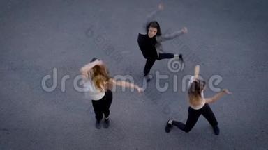 <strong>一</strong>组三名女舞蹈演员晚上在<strong>一条街</strong>上跳舞，从上面看到她们的身影